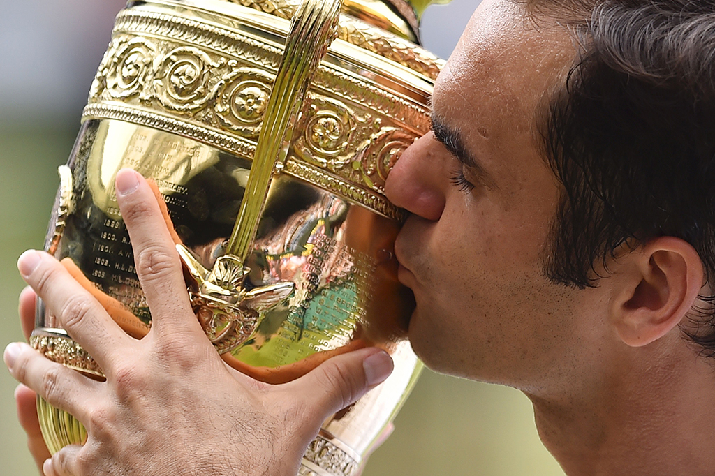 Il trofeo del singolare maschile nelle mani di Roger Federer