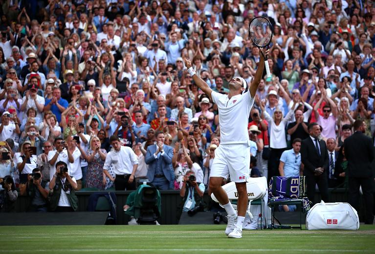 Federer alza le braccia a Wimbledon nel 2019 dopo la vittoria in semifinale con Nadal